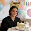 Congrats grad headband from graduation cake topper set worn by graduate beside decorated celebration cake