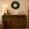 Norfolk pine Christmas garland on wood console table with matching green wreath wall decor