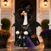 23-inch porch goose wearing witch dress and broom on lit front porch at night