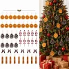 The full 48-piece set laid out in rows – 18 orange slices, 10 pinecones, 6 berry picks, 6 velvet bows with bells and 8 cinnamon bundles – next to a decorated tree