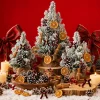Tabletop display – flocked mini trees dressed with orange slices, cinnamon bundles, pinecones, berries and bows, with candles and a wooden bowl on a red backdrop