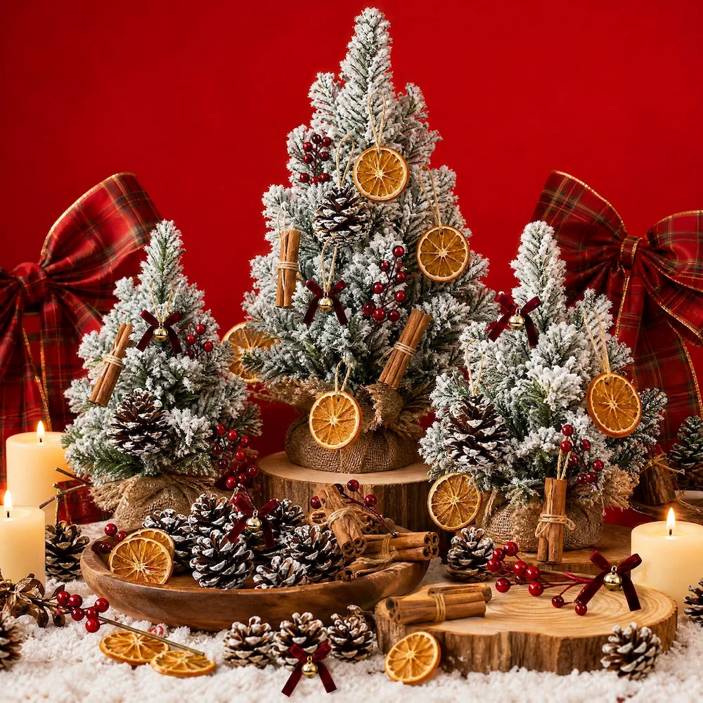 Tabletop display – flocked mini trees dressed with orange slices, cinnamon bundles, pinecones, berries and bows, with candles and a wooden bowl on a red backdrop