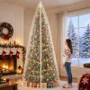 Scale reference – a woman standing beside a 10 ft decorated artificial tree zipped inside the clear upright storage cover