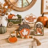 Fall wooden signs and bead garland arranged on a shelf with a vase of dried stems and pumpkins, no tray