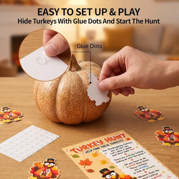 Setting up the turkey hunt – hand pressing a glue dot onto a paper turkey to hide it near a pumpkin