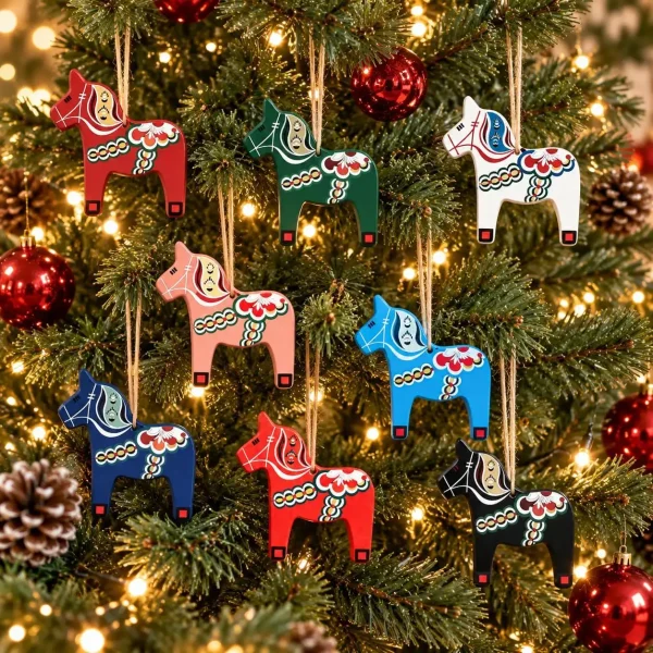Close-up of the eight painted Dala horse ornaments hanging among red baubles and lights on the Christmas tree