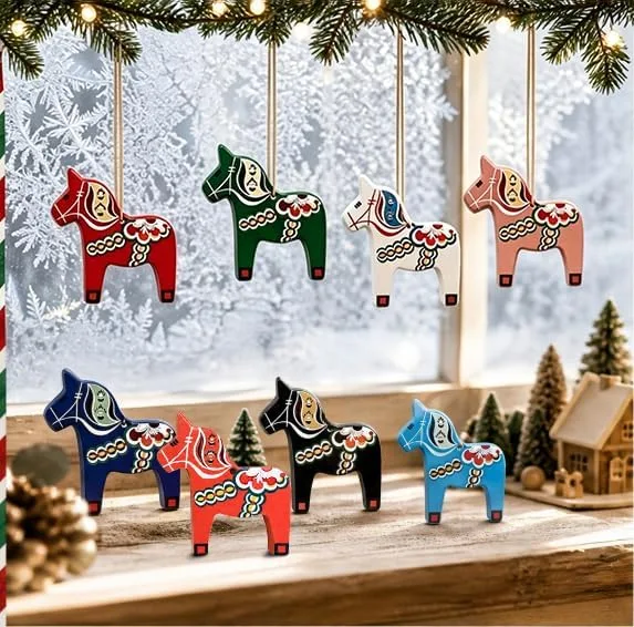 Dala horse ornaments hanging in front of a frosted winter window