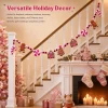 Versatile holiday decor – the pink gingerbread garland running along a staircase banister above a fireplace with pink stockings and gifts