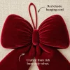 Close-up of the red velvet bow on linen showing the velvet pile and the red elastic hanging cord at the top
