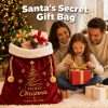 Family opening gifts next to the burgundy velvet Santa sack on Christmas morning